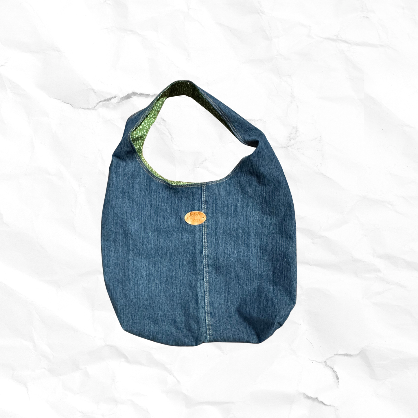 Blue denim bag with a gold tag on a white background