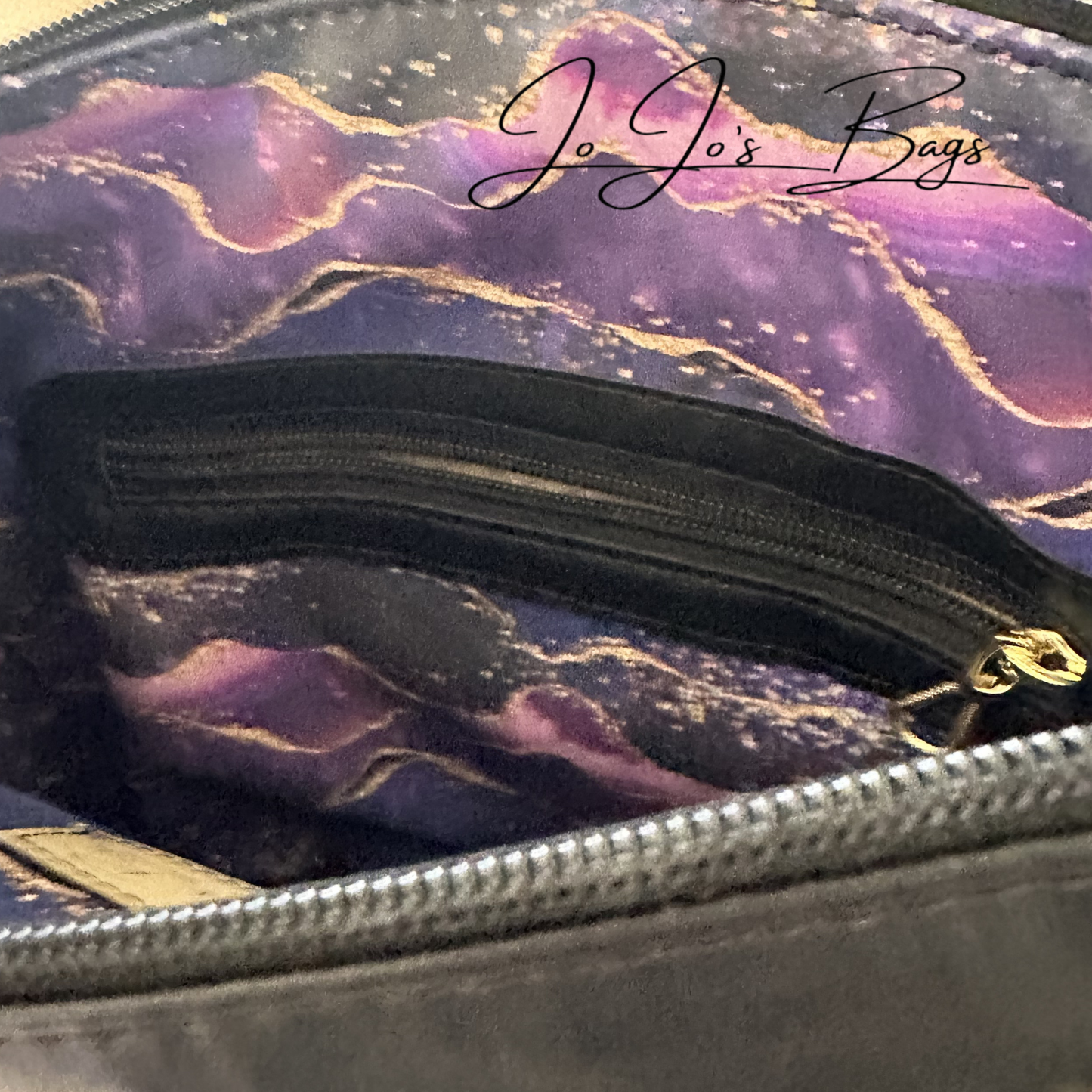 Close-up of the interior of a zippered bag showing a purple and gold galaxy-patterned lining with a black zipper and gold pull, plus the script brand name Jo Jo's Bags.